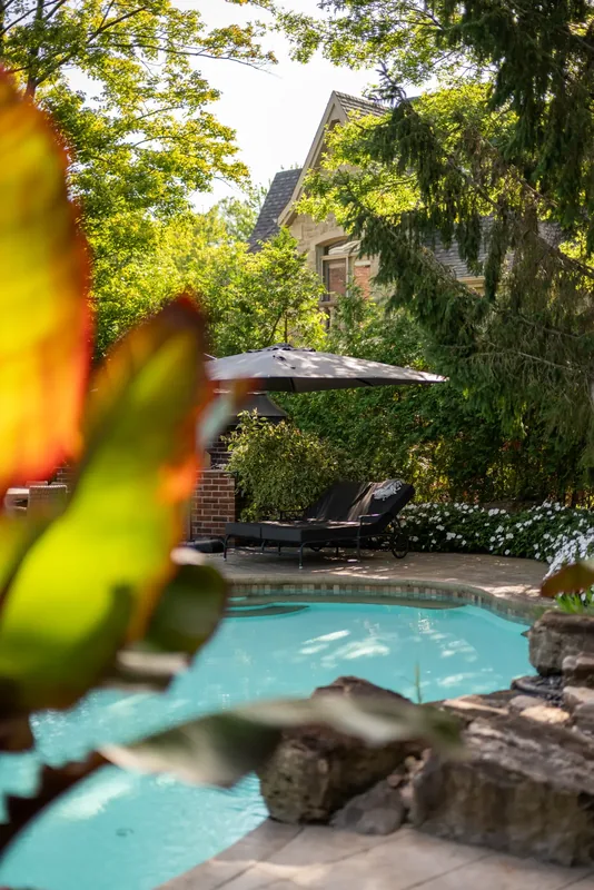 Natural boulder rock garden with tropical foliage at the water’s edge