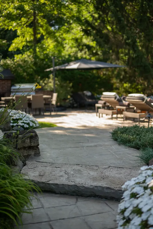 Stone paving, natural stone steps, and lush plantings around the terrace