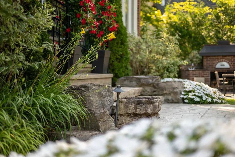 Stone paving, natural stone steps, and lush plantings around the terrace