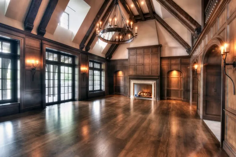 Great hall with a vaulted timber ceiling, a wrought-iron chandelier, wood panelling, and a fireplace
