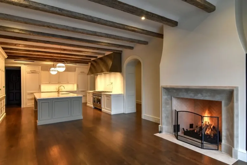 Living room fireplace with a view through to the kitchen island and range