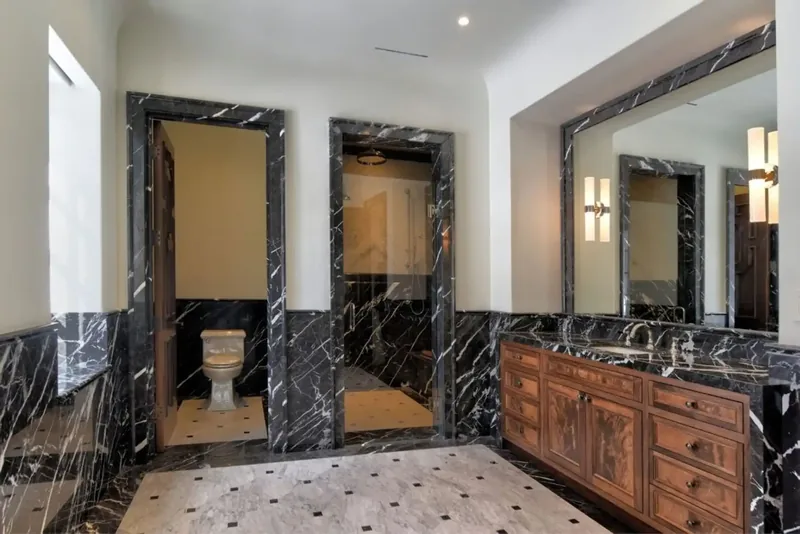 Bathroom in black and white marble with a carved wood vanity