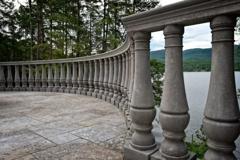 Curved stone balustrade above the lake, with the mountains on the horizon
