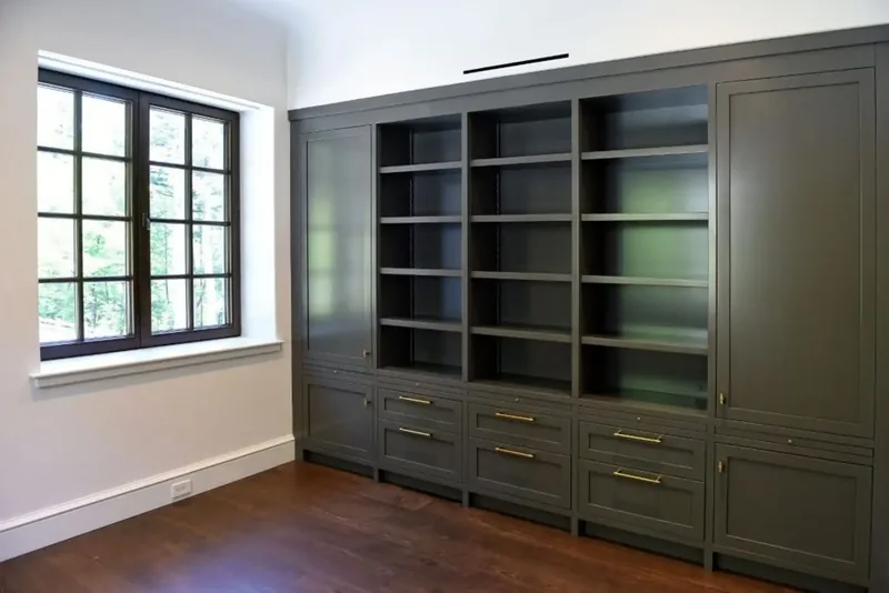 Bedroom with built-in cabinetry and open shelving in a deep green finish
