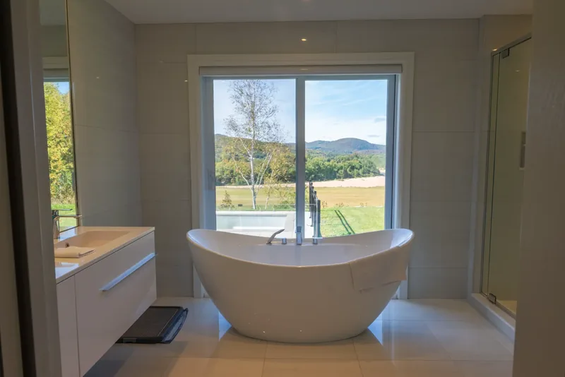 Freestanding soaking tub before a window overlooking the fields