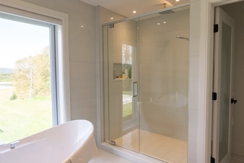 Frameless glass shower beside the freestanding tub