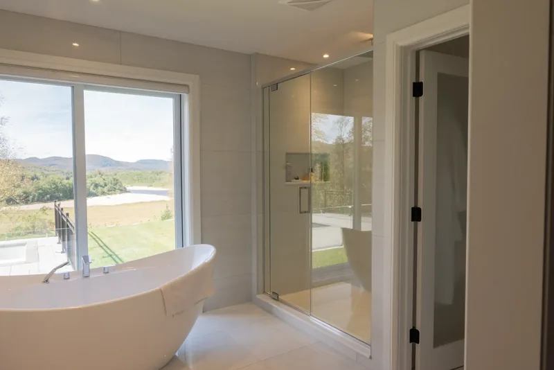 Frameless glass shower beside the freestanding tub