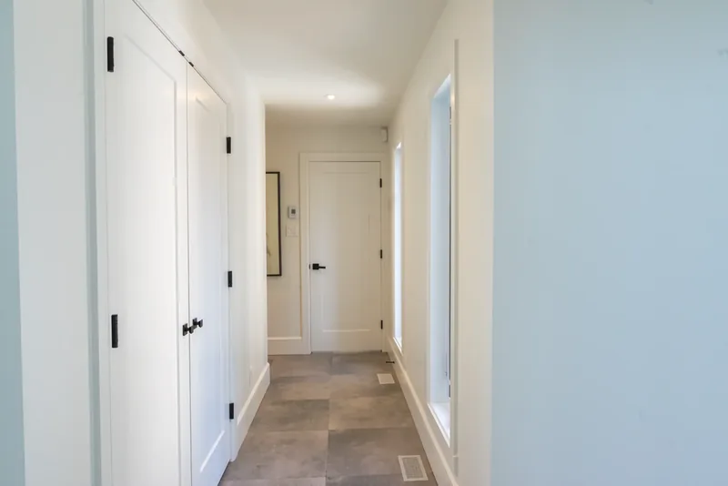 Hallway with a stone-look tile floor and white panel doors