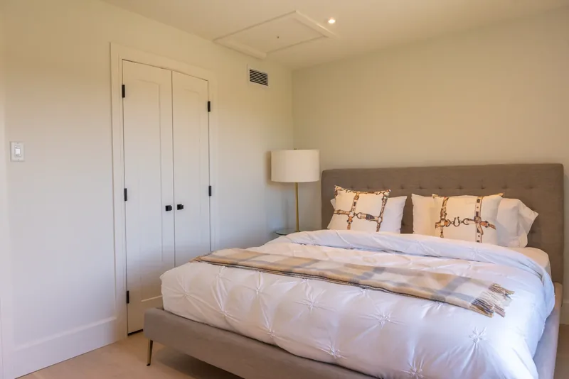 Bedroom with an upholstered headboard and a reading lamp