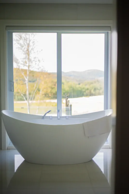 Freestanding soaking tub before a window overlooking the fields