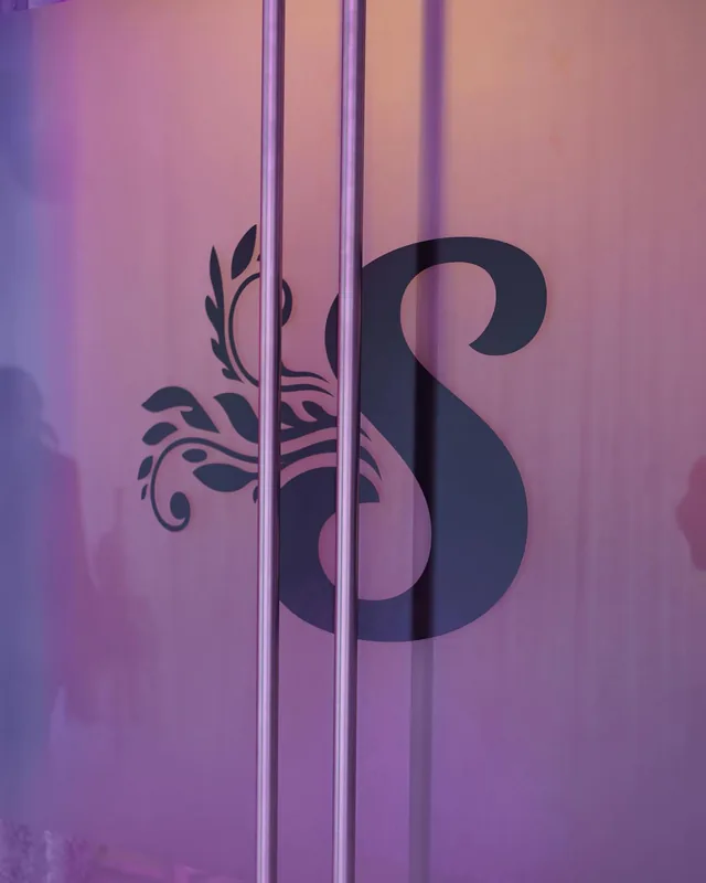 Frosted glass door with Sofia’s S monogram and two tall stainless steel pulls